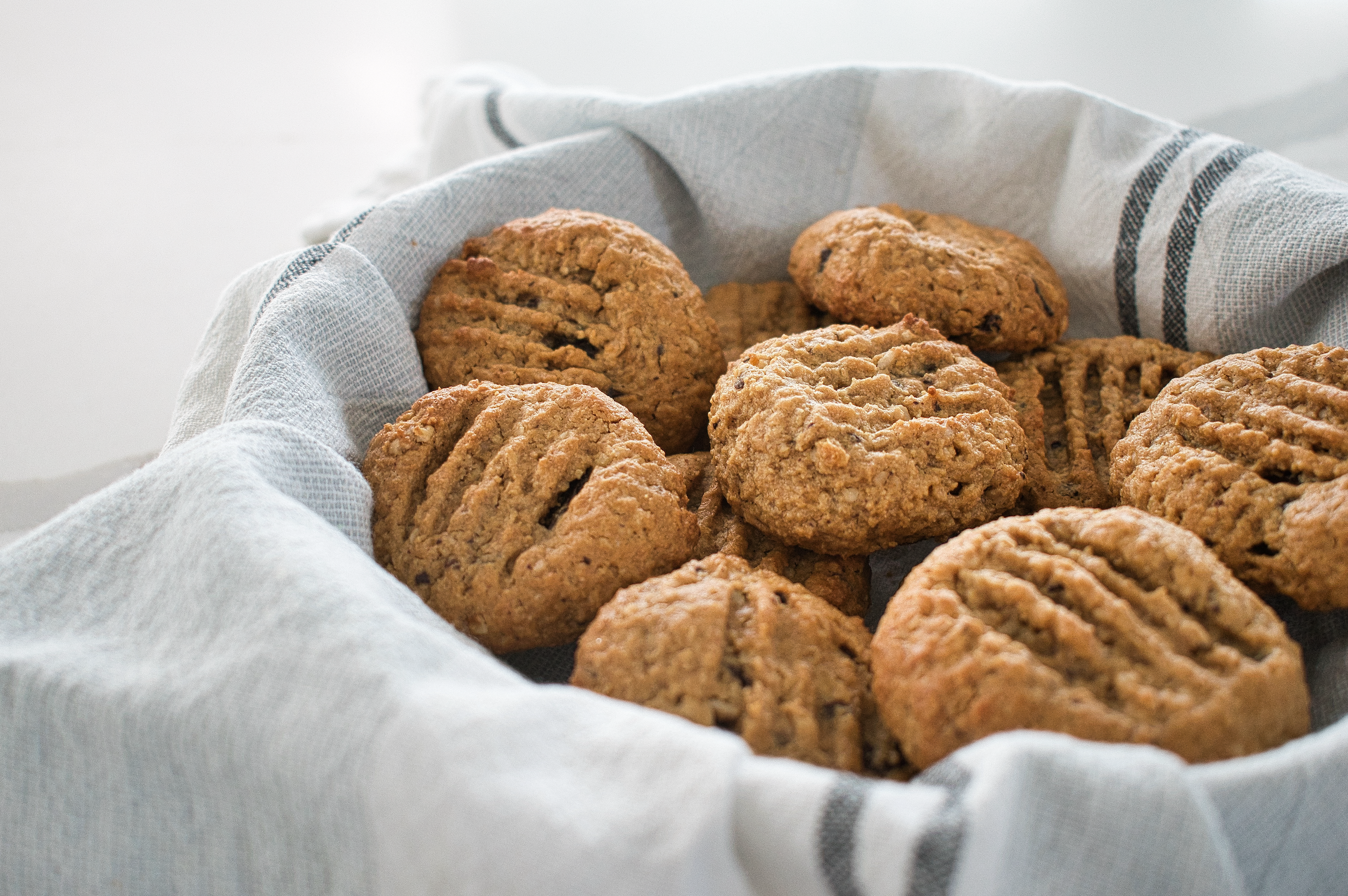 Basket of Low FODMAP Peanut Butter Chocolate Chip Cookies with a gray cloth on a white background