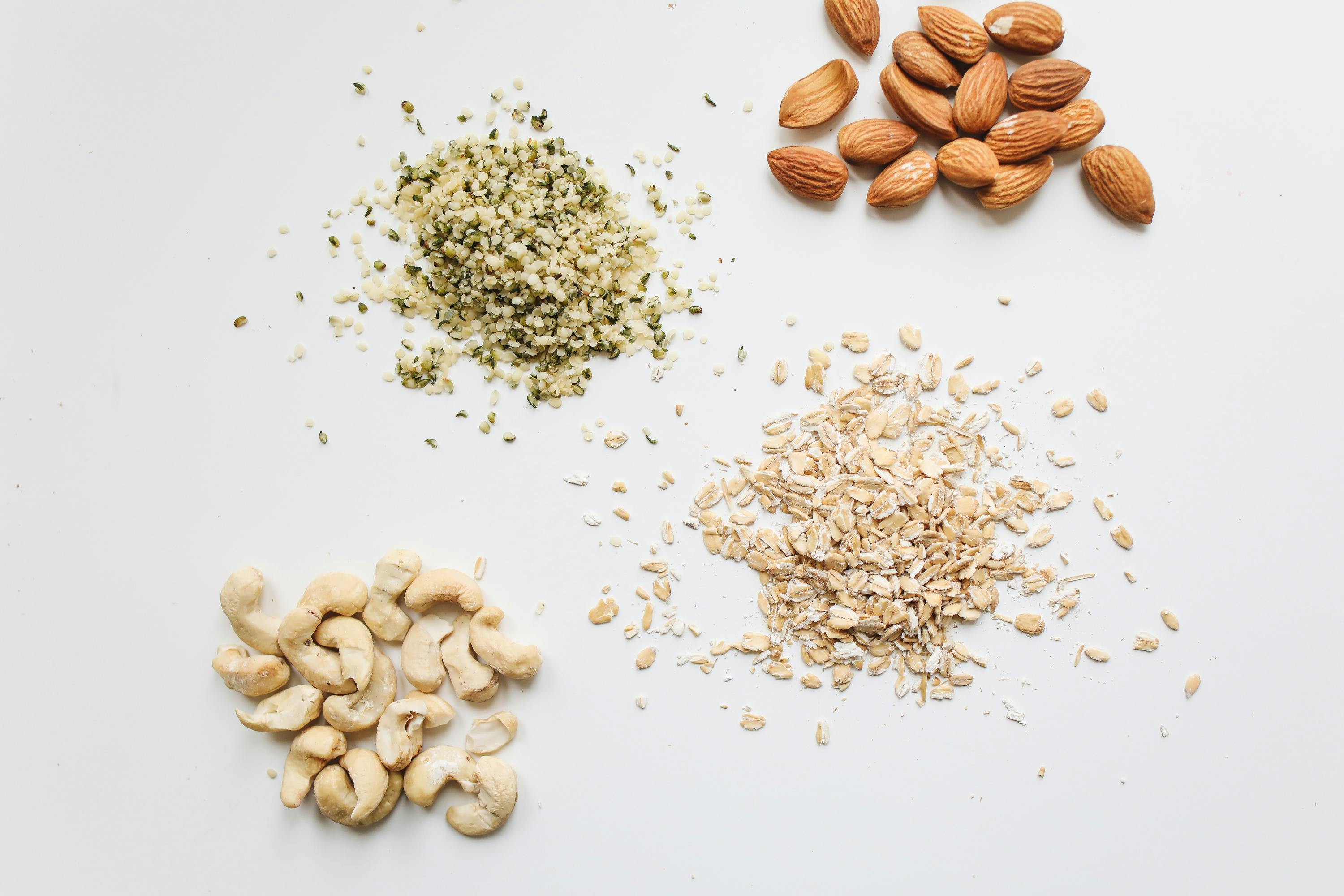 Assorted nuts and seeds on a light gray background